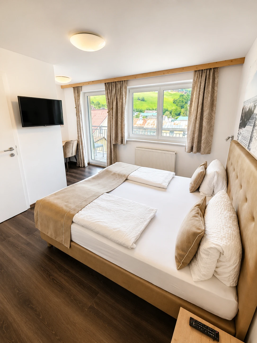 Helles Doppelzimmer in warmen Beigetönen mit Balkon